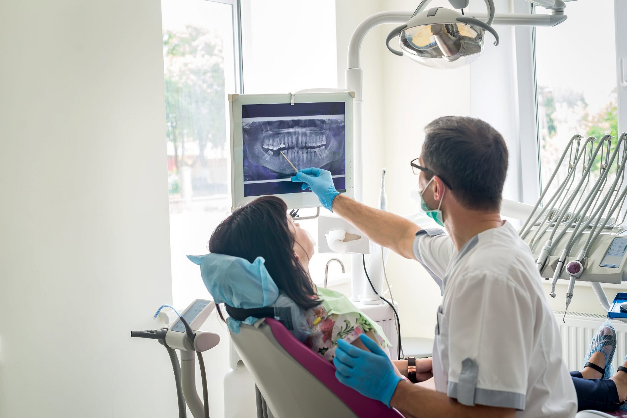 Doctor dentist showing patient’s teeth on X-ray